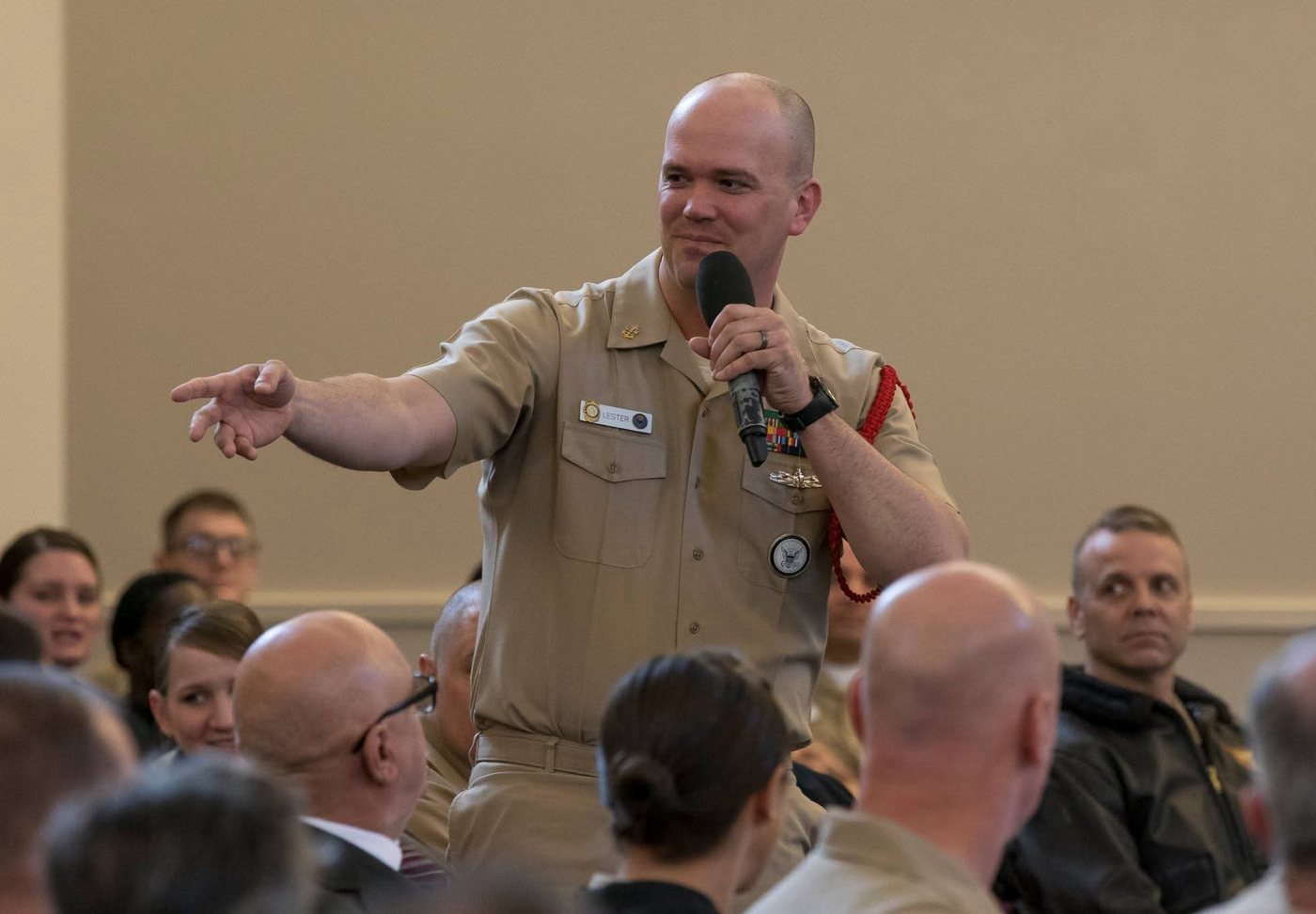 Ryan addressing a room in uniform, microphone in hand